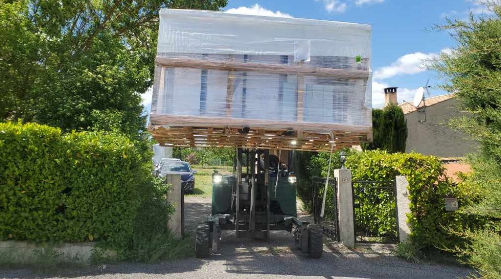 un abri de piscine livré par un chariot élévateur