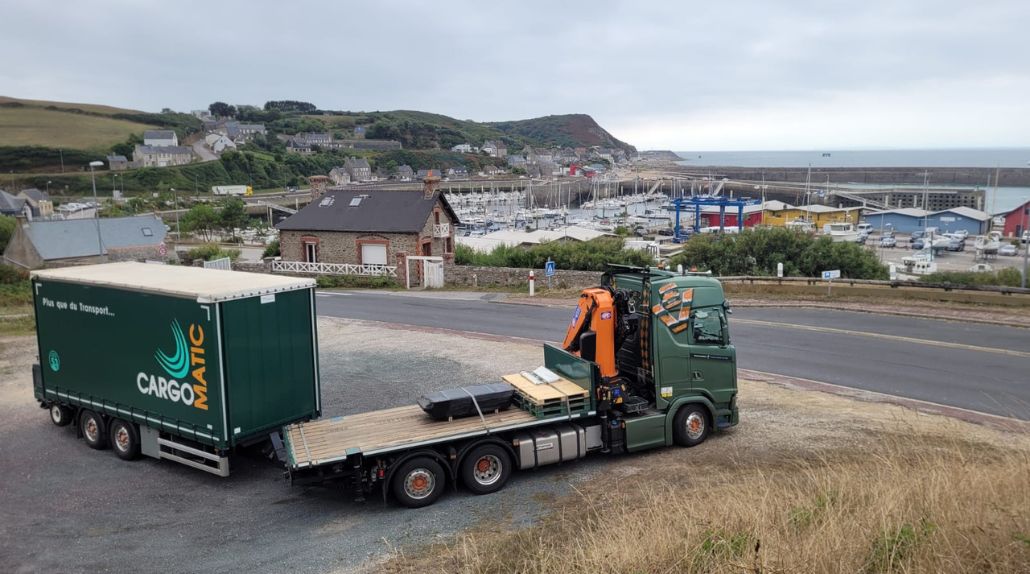 Un camion plateau grue avec remorque rideaux et chariot embarqué