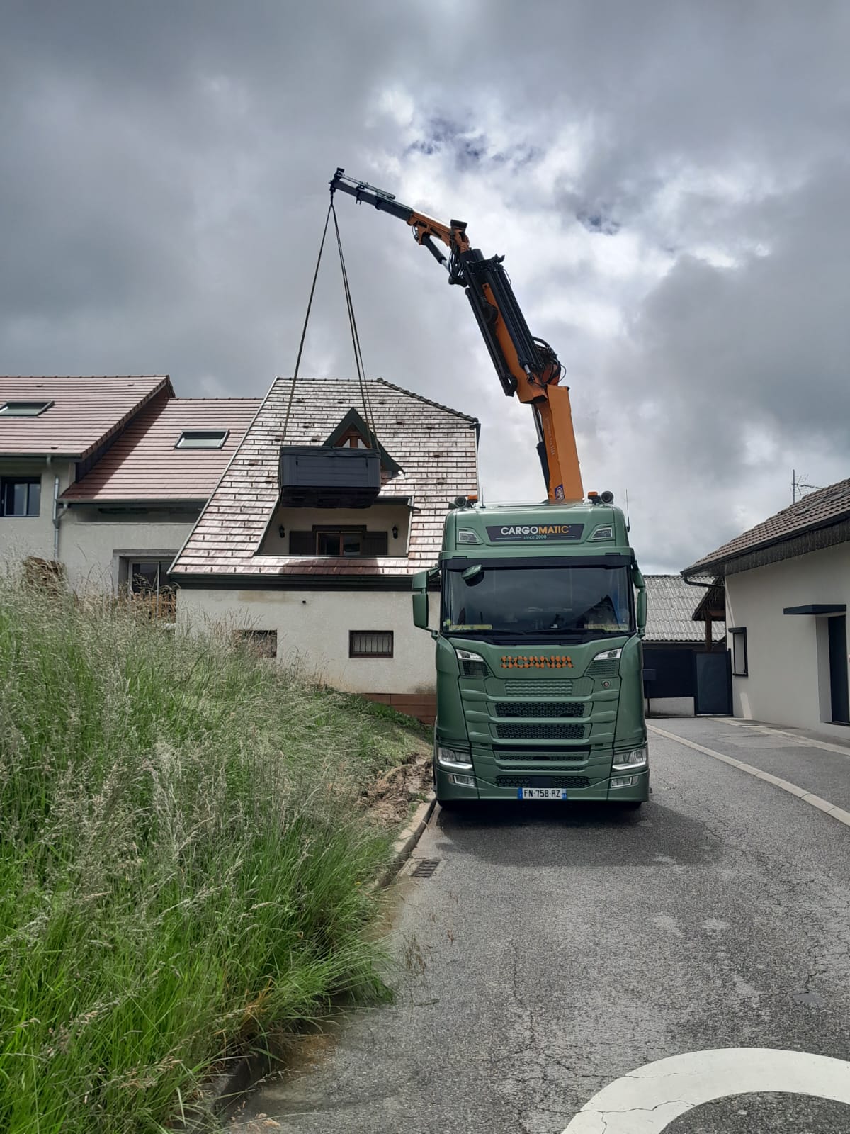 Une grue qui dépose un spa dans le toit d'une maison