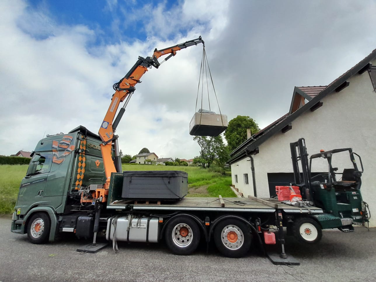 Une grue qui dépose un spa sur un balcon